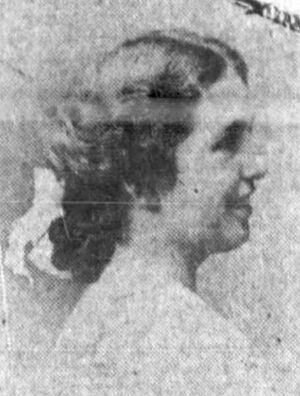 A young white woman in profile, smiling, hair dressed to the nape with a white bow.