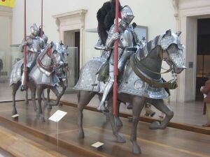 Three statues of riders and horses in armour