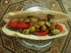 Sandwich filled with olives and sliced tomatoes