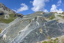 Glacial striations on an eroded rock alongside the Moiry Glacier, Switzerland, visible in the lower right quarter of the image