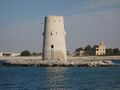 Al-Maqta' Tower (Arabic: بُرْج ٱلْمَقْطَع, romanized: Burj Al-Maqṭaʿ; front) and Al-Maqta' Fort (Arabic: حُصْن ٱلْمَقْطَع, romanized: Ḥuṣn Al-Maqṭaʿ; back), just outside the island of Abu Dhabi