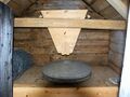 The grain is poured into the tract and the flavour is gathered on the desktop surrounding millstones and is wiped down to a bin in the front of the table